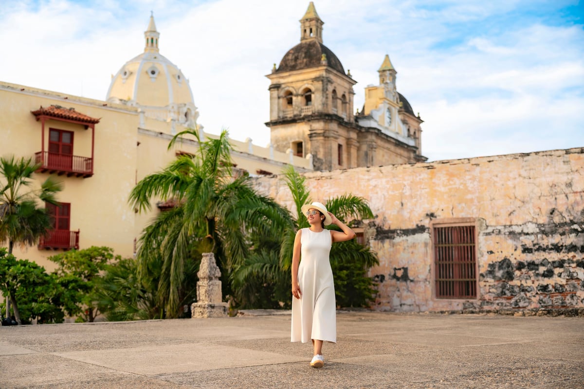 Young smiling Latin woman poses near a colonial church in Cartagena