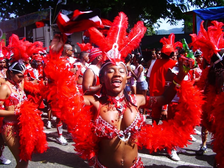 Masqueraders in red feathered costumes parading during Trinidad Carnival