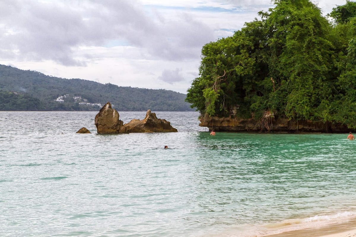 Clear turquoise water and a rocky, tree-covered point at Cayo Levantado in Samaná Bay, Dominican Republic