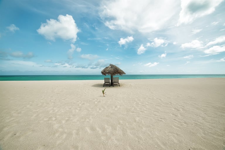 Beach umbrella and loungers on the pink sand of Barbuda